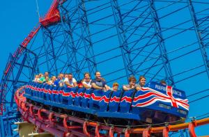 a group of people riding on a roller coaster at Velvet Coaster Apartments in Blackpool