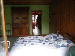 a bedroom with a bed and green walls at le clermontain in Les Clérimois