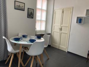 una sala da pranzo con tavolo e sedie bianchi di Casa Italia a Spotorno