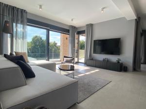 a living room with a couch and a flat screen tv at Villa Anthea Paola in Nedeščina