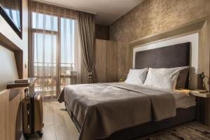 Una habitación de hotel con una cama y una ventana grande. en Boutique Apartments - Sevtopolis, en Kazanlak