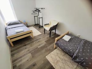 a living room with two beds and a chair at Comfort Apartment for 6 & Loggia & Free Parking in Žilina