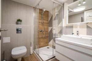 uma casa de banho com um chuveiro, um WC e um lavatório. em BpR Cerebria Home em Budapeste