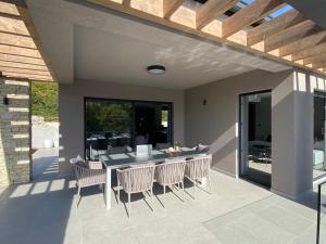 a patio with a table and chairs on a patio at Villa Anthea Paola in Nedeščina
