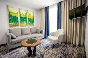 a living room with a couch and a table and a chair at Avenue Park Hotel in Yusufkhona