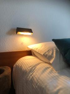 a bedroom with a bed and a light on the wall at duunn koksijde in Koksijde