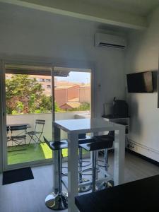 a kitchen with a table and chairs and a window at T2 Bis Design et Lumineux à 200m du Village Naturiste in Cap d'Agde