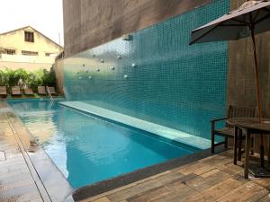 a swimming pool with a table and an umbrella at Akile Movva in São Paulo