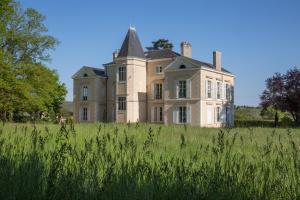 une vieille maison au-dessus d'un champ herbeux dans l'établissement Manoir des Etrichets, à Saint-Saturnin