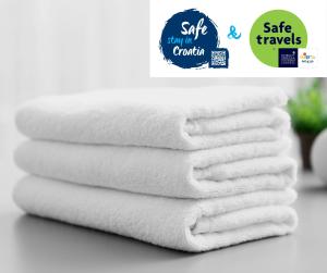 stos białych ręczników na ladzie w obiekcie Apartments & Rooms Jokovic w mieście Mlini
