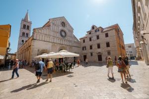 a group of people walking around a street in a city at Zadar Old City Apartment Leonardo in Zadar