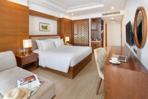 a hotel room with a bed and a desk at Paris Deli Danang Beach Hotel in Danang
