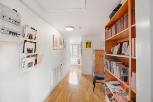 a hallway with wooden bookshelves and a chair in a room at Korinth Bed & Breakfast in Fåborg