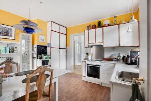 a kitchen with yellow walls and white cabinets at Korinth Bed & Breakfast in Fåborg
