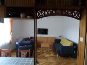 レーヴフュロップにあるSzabadidő Vendégházのリビングルーム(青いソファ、テレビ付)