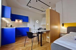 a bedroom with blue cabinets and a table and a bed at ZACHÁR APARTMAN in Sopron