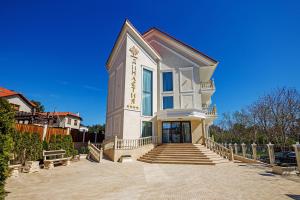 a large white house with stairs in front of it at Dynasty Hotel in Gelendzhik