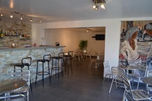 ein Restaurant mit Tischen und Stühlen und eine Bar in der Unterkunft Résidence U Nebbiu in Olmeta-di-Tuda