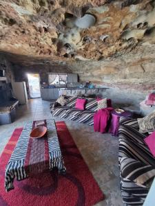 Habitación con cama y sofá en una cueva en Kings View Cave, en Clanville