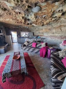 a room with a bed and a couch in a cave at Kings View Cave in Clanville