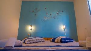 a bed with two pillows and a blue wall at The Sea House Apartments in Vis