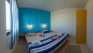 a bedroom with a large bed with blue walls at The Sea House Apartments in Vis