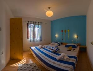 a bedroom with a large bed with blue walls at The Sea House Apartments in Vis