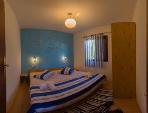 a bedroom with a large bed with blue walls at The Sea House Apartments in Vis