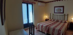 a bedroom with a bed and two windows at La Casa del Regidor in Fermoselle