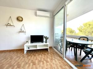 ein Wohnzimmer mit Fernseher und Esstisch in der Unterkunft APARTBEACH CYE 6 CLIMATIZADO y JUNTO PLAYA in Salou