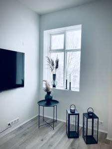 a living room with two tables and a window at Day Dream Central Akureyri Two Bedroom Apartment in Akureyri