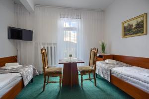 クリニツァ・ズドルイにあるDom Wczasowy Zdrowieのベッド2台、テーブル、椅子が備わる客室です。