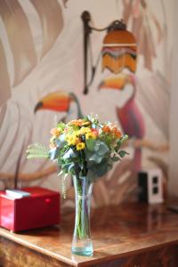 un vase de fleurs sur une table avec une lampe dans l'établissement Domaine Gille, à Comblanchien