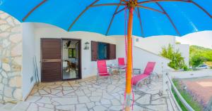 a patio with a table and chairs and an umbrella at The Sea House Apartments in Vis