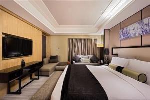 Habitación de hotel con cama grande y TV en Mels Weldon Dongguan Humen en Dongguan
