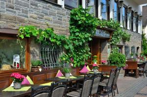 ein Restaurant mit Tischen und Stühlen vor einem Gebäude in der Unterkunft Hotel Lellmann in Löf