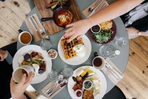 uma mesa coberta com pratos de comida e chávenas de café em Hotel Burgstallerhof em Feld am See