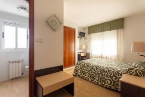 O Mesón Do Vento にあるHotel Canaima Bruma 1,5 k Caminoのベッドと窓のあるホテルの部屋 +18枚の写真