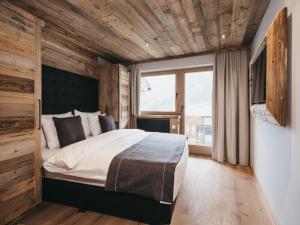 a bedroom with a large bed and a large window at VAYA Zillertal in Aschau