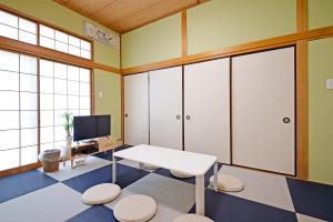 a room with a table and a tv and some windows at Oji Natural Cosy House in Tokyo