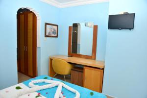 a bedroom with a desk and a mirror and a bed at Side Temple Hotel in Side