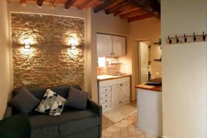 een woonkamer met een bank en een keuken bij tra Miracoli e Cavalieri in Pisa