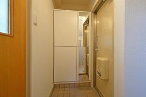 a hallway with a glass refrigerator in a room at Oji Natural Cosy House in Tokyo