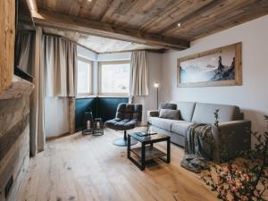 uma sala de estar com um sofá e uma cadeira em VAYA Zillertal em Aschau