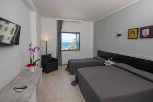 une chambre d'hôtel avec deux lits et un canapé dans l'établissement Hotel Hopps, à Mazara del Vallo
