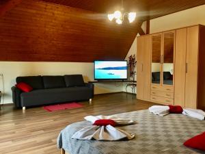 a living room with a couch and a flat screen tv at Marta Guest House in Gyenesdiás
