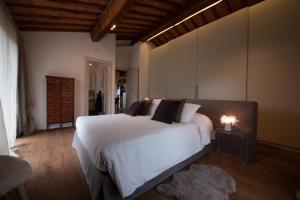 a bedroom with a large white bed with a lamp on a table at LA RIMESSA EXPERIENCE-Dream Holiday Home in Montaione +107 photos