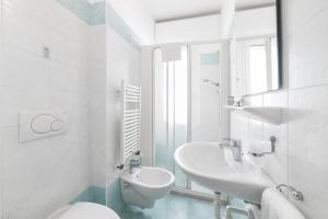a white bathroom with a sink and a toilet at Amalfi smart Rooms & Apartments - Ideale per Ragazzi in Riccione +16 photos