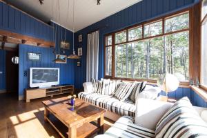 una sala de estar con paredes azules y muebles blancos. en Samblamaa Guesthouse en Rannaküla