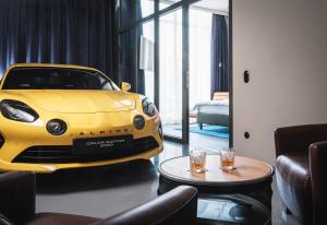 um carro amarelo estacionado numa sala com uma mesa em AMERON München Motorworld em Munique